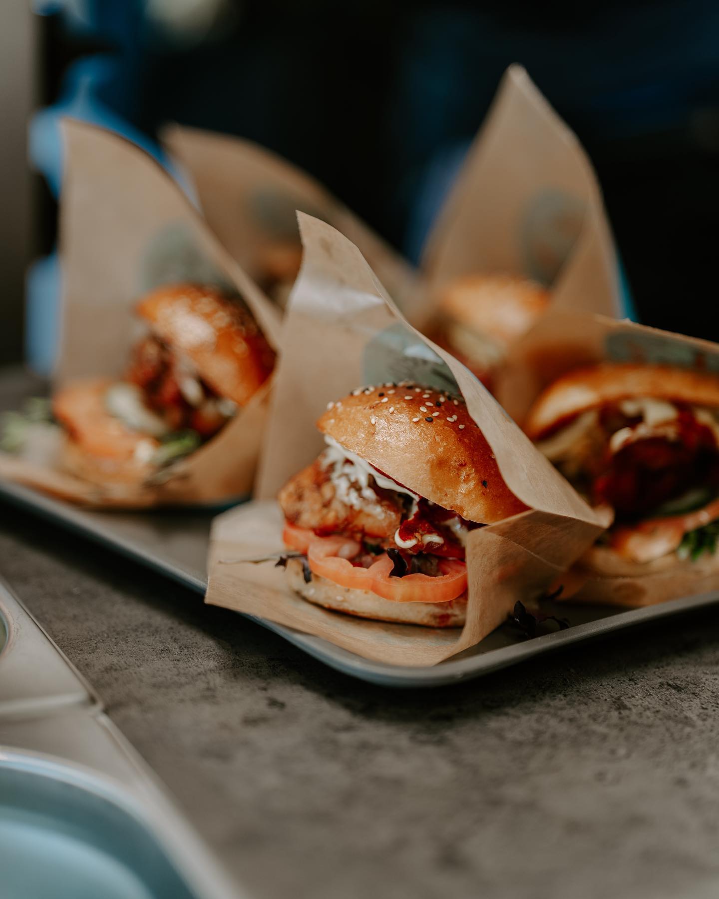 Gourmet burgers wrapped in custom printed burger bags in a rustic style.